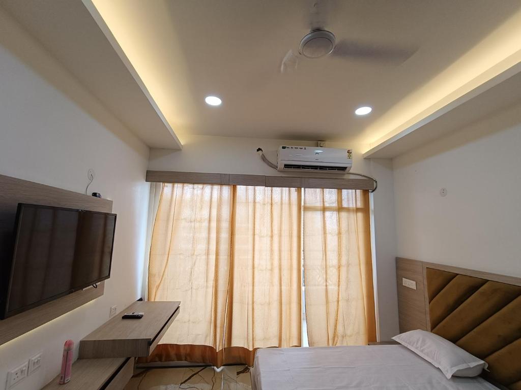 a bedroom with a bed and a television on the ceiling at Aarohi studio hotels in Noida