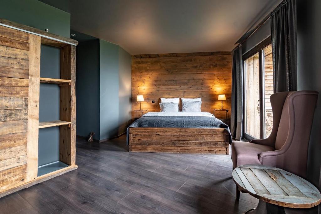 een slaapkamer met een bed en een houten muur bij Montem in Matraszentistvan