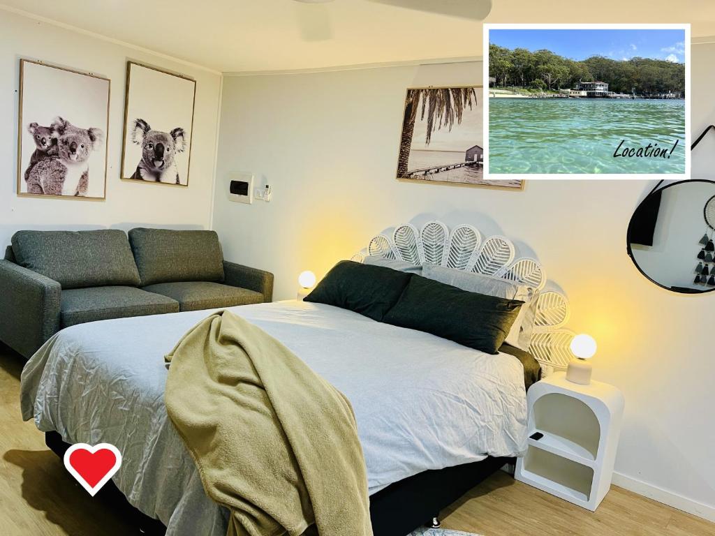 een slaapkamer met een bed en een bank bij 2Bays Studio- Walk to 2 Beaches! Perfect Location with Private Courtyard & BBQ in Nelson Bay