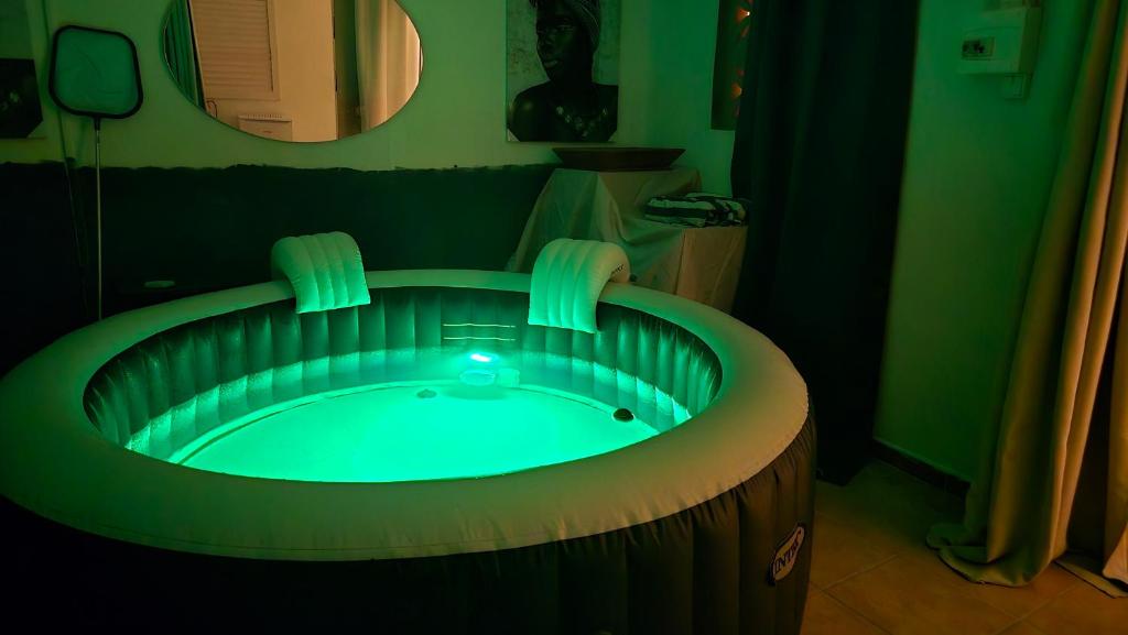 a jacuzzi tub with a light in a bathroom at Evasion Authentique en Tiny House - 1 Champagne OFFERT - Le Paradis des Petits Voyageurs in Le Diamant