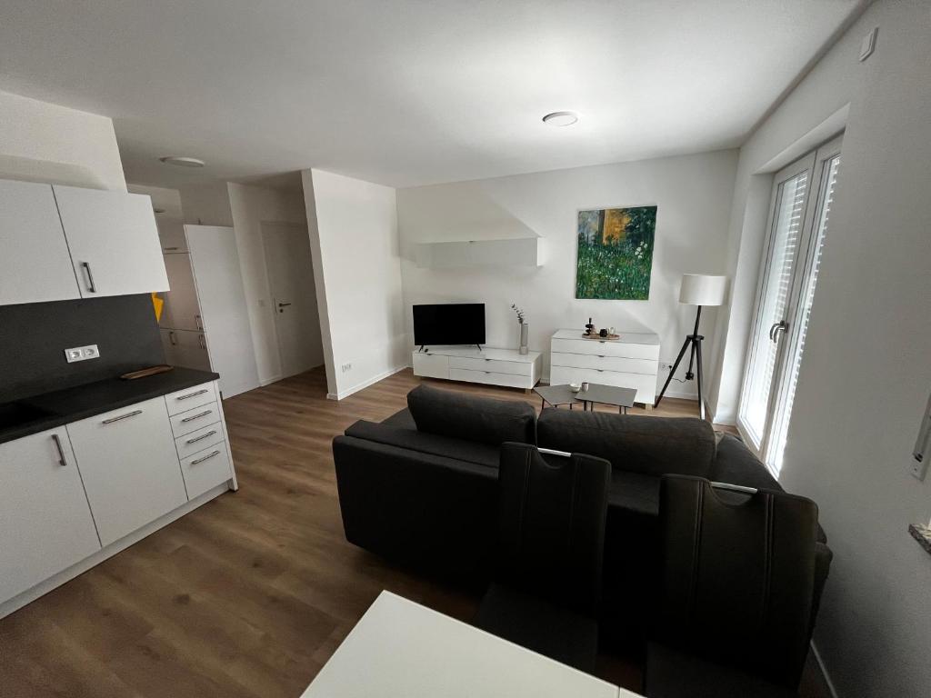 a living room with a black couch and a tv at Fewo Altes Rathaus in Bamberg