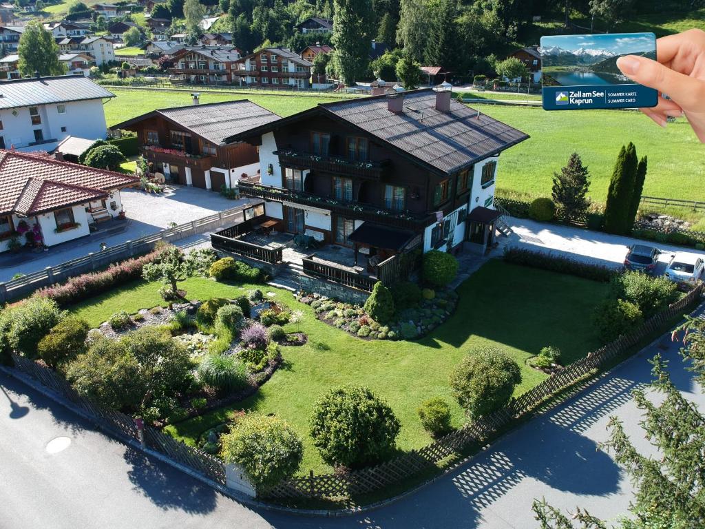 une personne prenant une photo d'une maison dans l'établissement Pension Alpentraum, à Zell am See