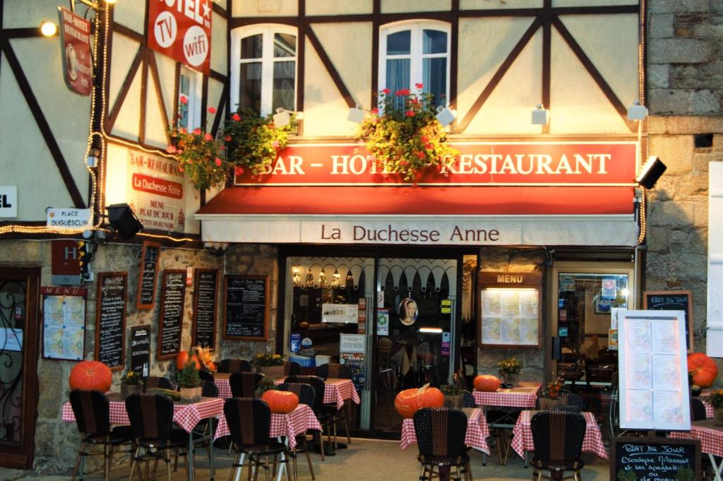 um restaurante com mesas e cadeiras em frente a um edifício em Hotel Duchesse Anne em Dinan