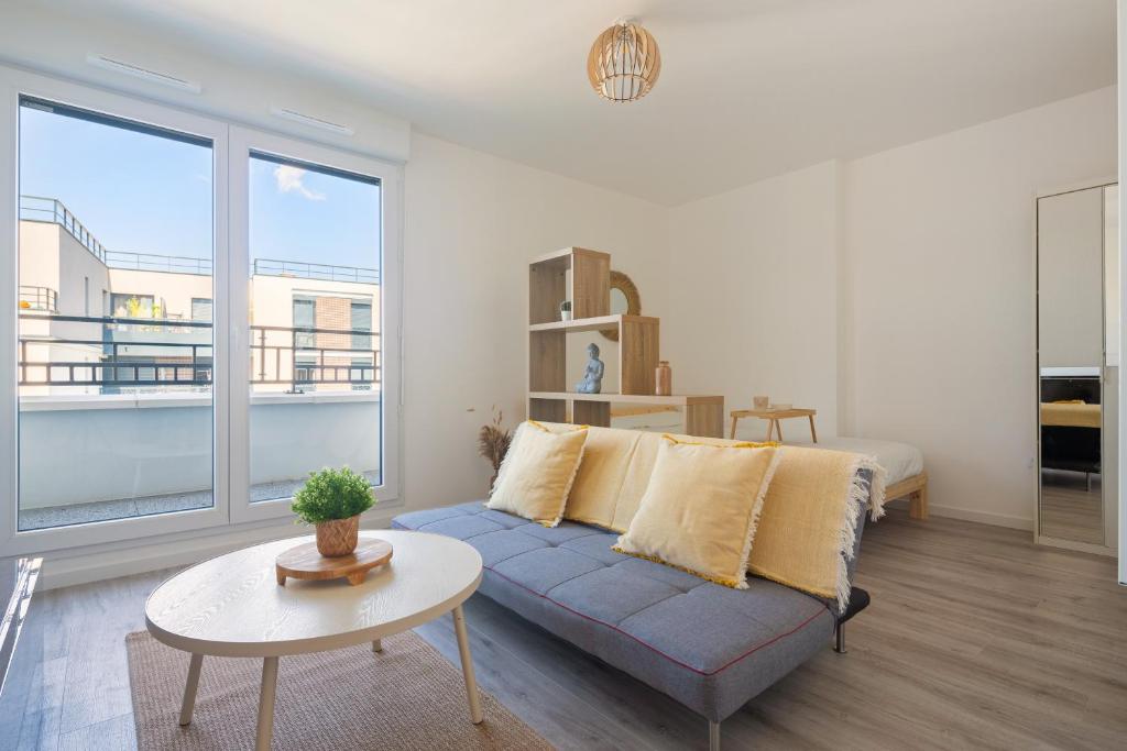 a living room with a blue couch and a table at Le Péruvien - Saint-Cyr-L'Ecole - Free Parking in Saint-Cyr-lʼÉcole