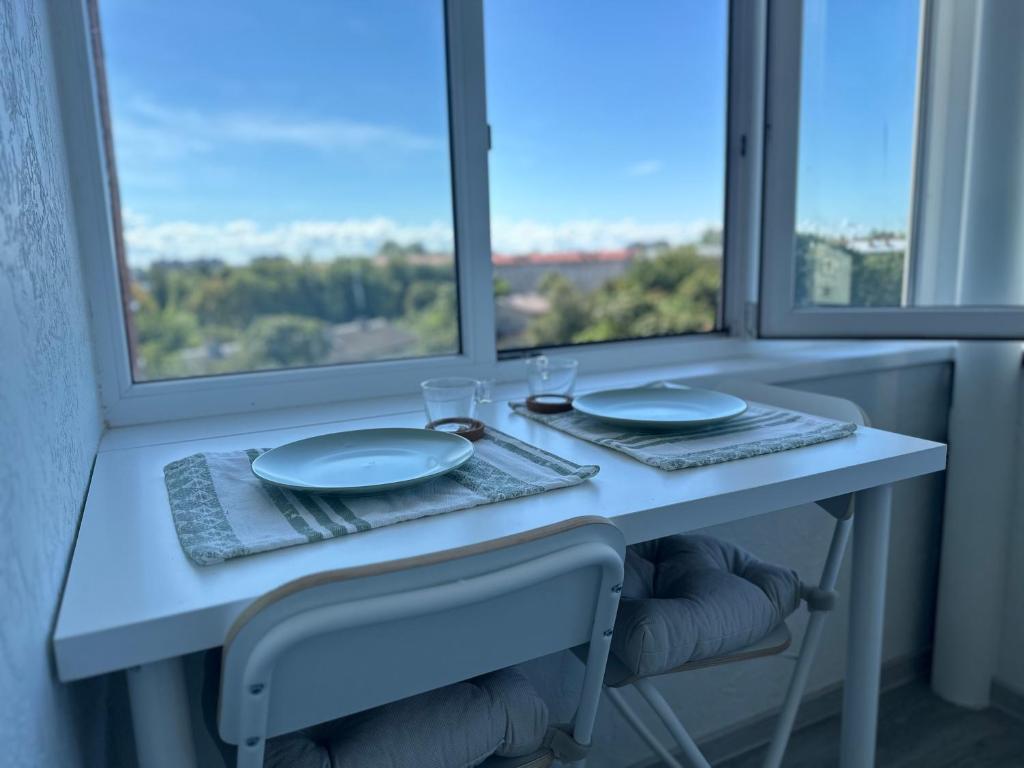 uma mesa com dois pratos e copos em frente a uma janela em Energy home em Narva