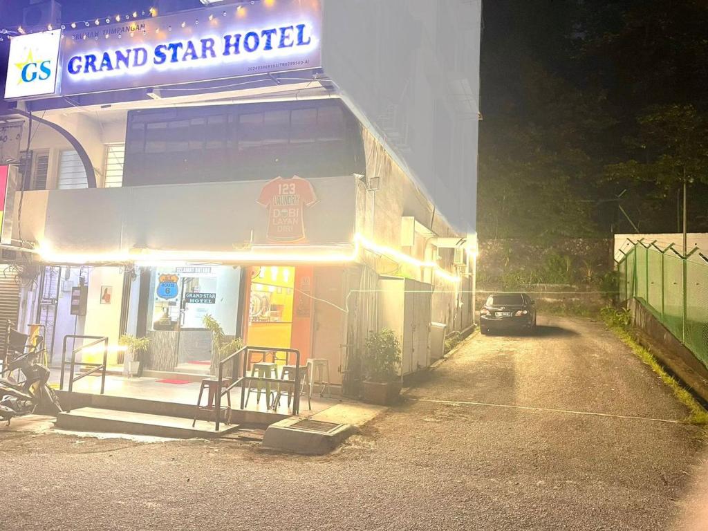 una macchina parcheggiata fuori da un grand hotel di notte di Grand Star Hotel a Batu Ferringhi