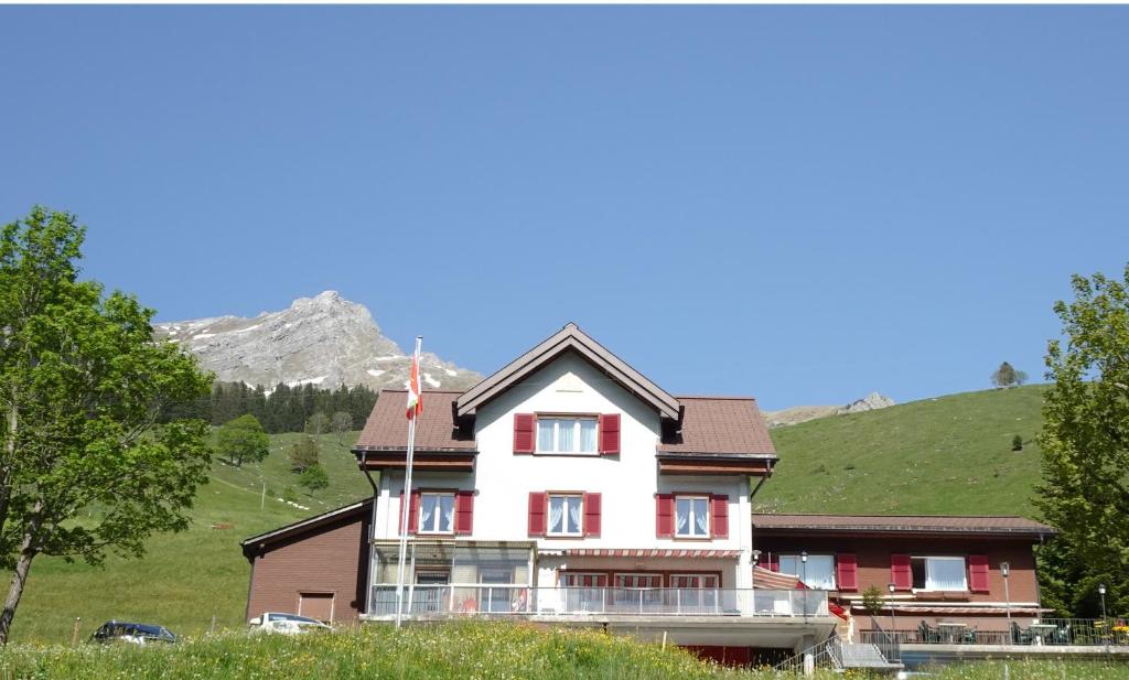 una casa grande con una montaña en el fondo en Gasthaus Schwand, en Engelberg