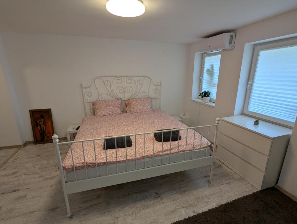 una camera da letto con un letto con lenzuola rosa e una finestra di Serene Studio a Bucarest