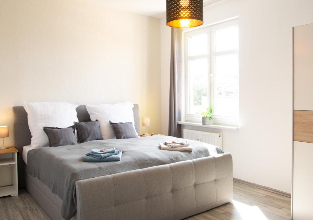 een slaapkamer met een groot bed en 2 handdoeken bij Ilmpartment Deluxe Suite - Vollausstattung - Boxspringbett - Wi-Fi - Netflix in Ilmenau