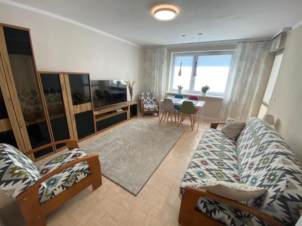 een woonkamer met een bank, een tv en een tafel bij Kaktusik in Suwałki