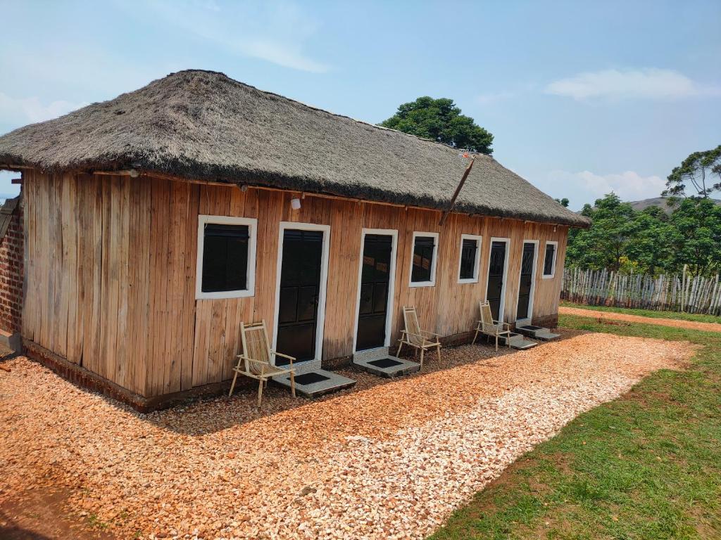 eine kleine Hütte mit zwei Stühlen und einem Dach in der Unterkunft Thatched Cottage Suites in Jinja