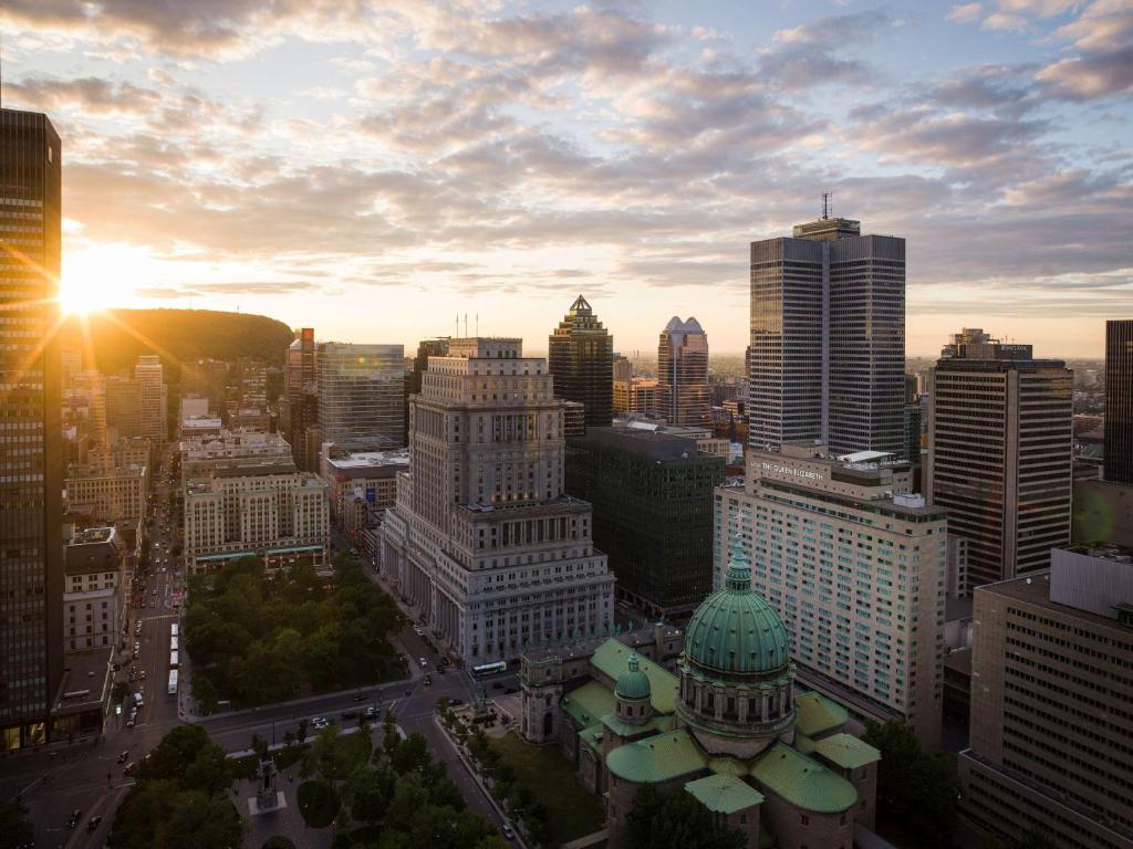 - une vue sur les toits de la ville et le coucher du soleil dans l'établissement Fairmont The Queen Elizabeth, à Montréal