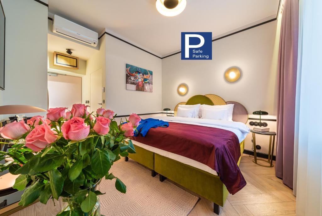 een hotelkamer met een bed met roze rozen bij SleepWell Boutique Apartments in Warschau