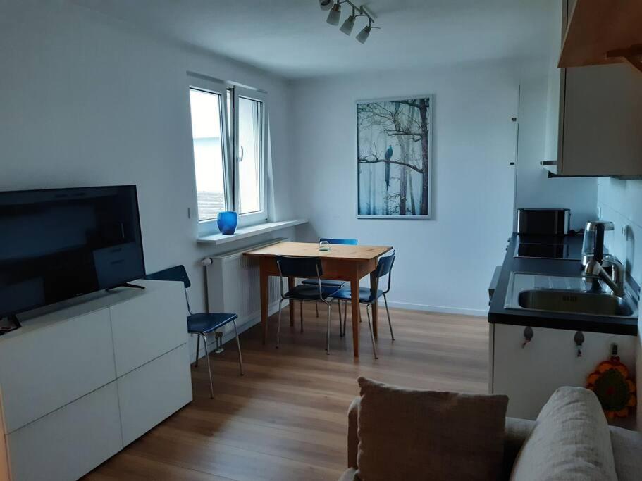 uma sala de estar com uma cozinha e uma mesa de jantar em Apartment mit Innenhof, Rasen und Parkplatz em Altlußheim