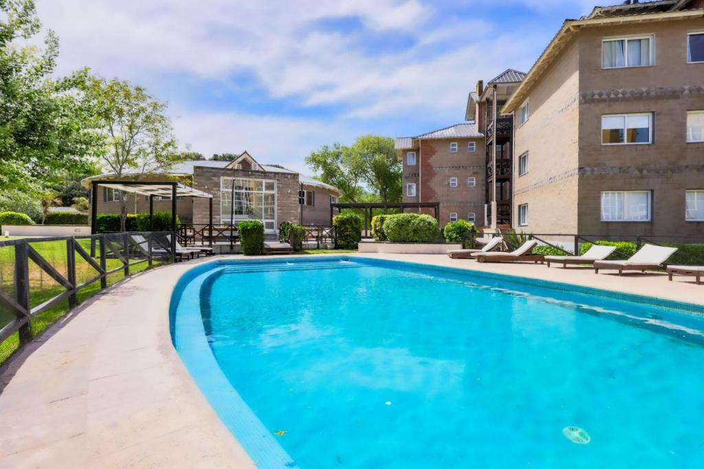 - une piscine dans l'arrière-cour d'un bâtiment dans l'établissement Victoria Village, à Carilo