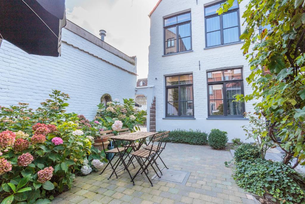 een patio met een tafel en stoelen voor een huis bij Hotel Bla Bla in Brugge