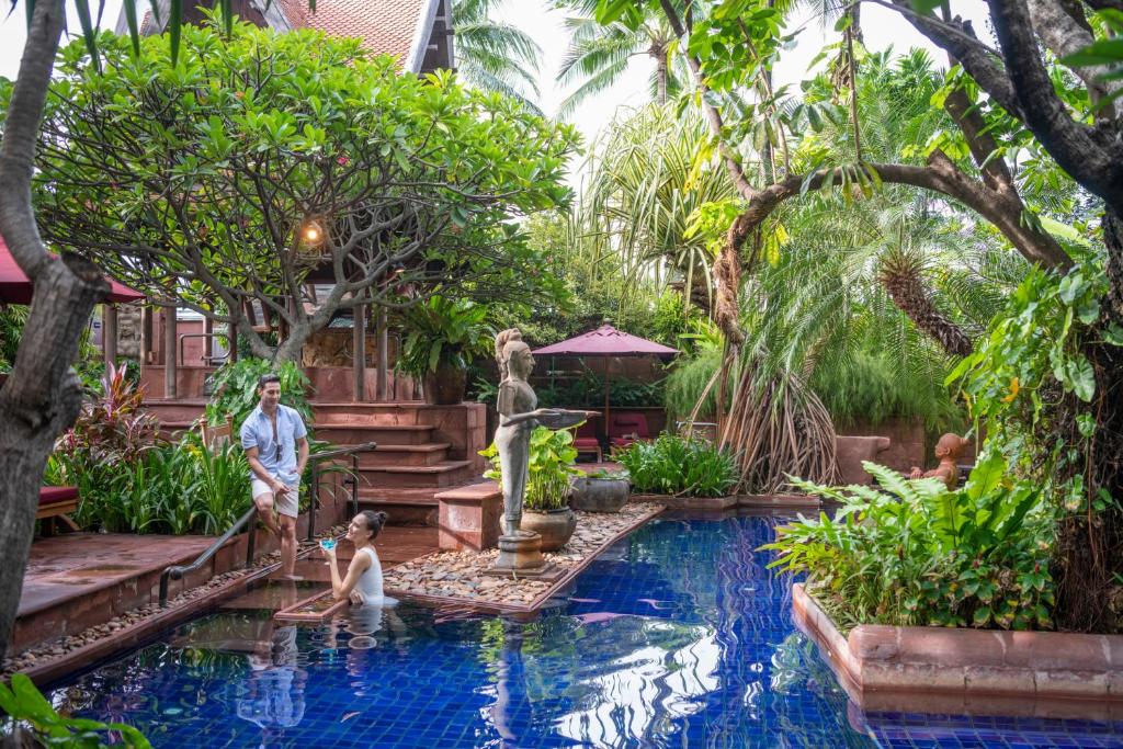 um grupo de pessoas em pé em uma piscina em um jardim em Sheraton Grande Sukhumvit, a Luxury Collection Hotel, Bangkok em Banguecoque