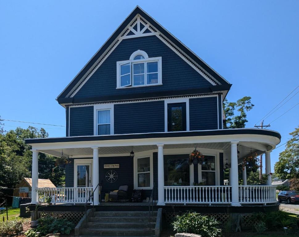 a blue house with a white porch and stairs at Rose & Thistle B&B Lunenburg in Lunenburg