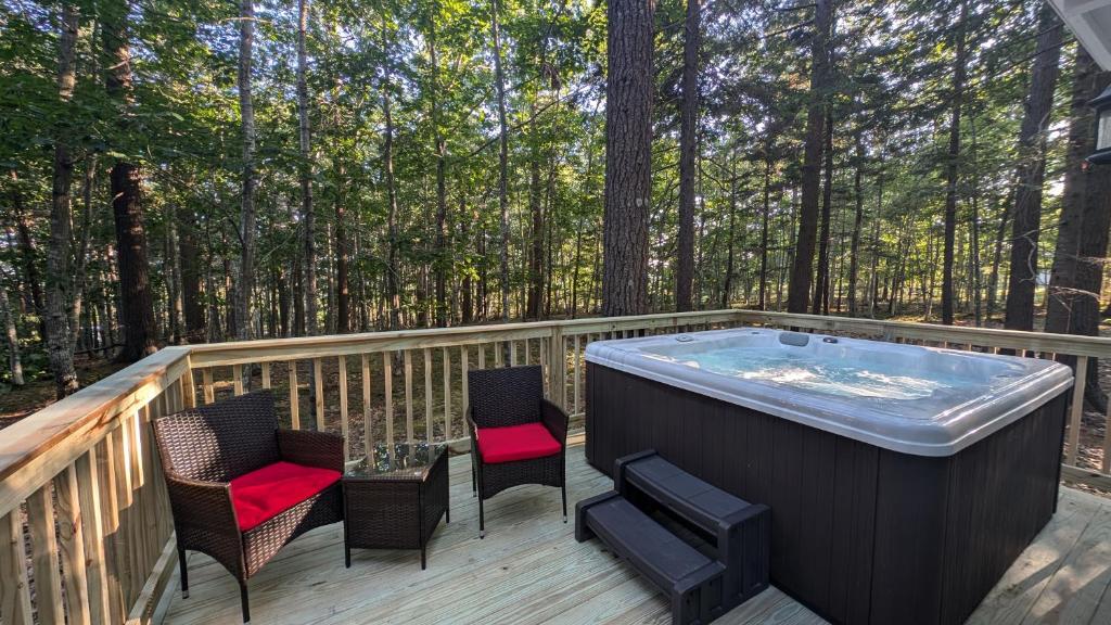 einen Whirlpool auf einer Terrasse im Wald in der Unterkunft Hinckleys Dreamwood Cottages in Bar Harbor