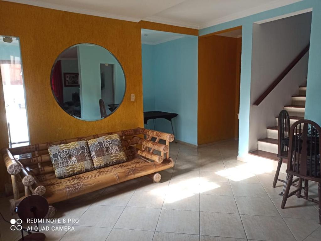 ein Wohnzimmer mit einem Sofa und einem Spiegel in der Unterkunft Litoral Norte Pousada in Caraguatatuba