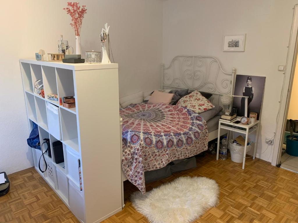 1 dormitorio con cama y estante para libros en Your cosy private Apartment, en Múnich