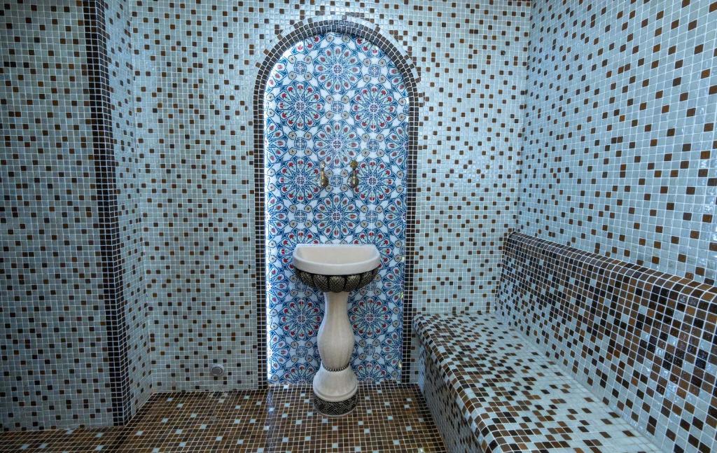 bagno con lavandino e finestra a mosaico di Garnet Hotel Tashkent a Tashkent