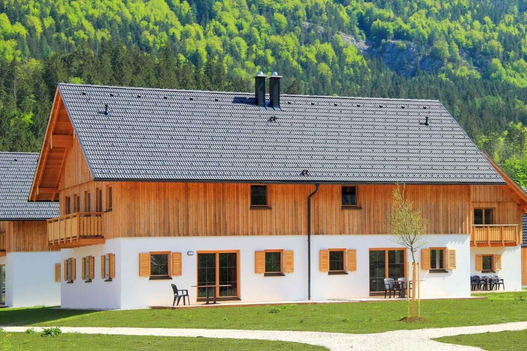 une grande maison en bois avec un toit en gambrel dans l'établissement Holiday Homes Obertraun/Oberösterreich 86, à Obertraun