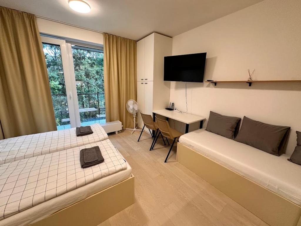 Habitación de hotel con cama y escritorio con ordenador en Bella Apartments Brno, en Brno