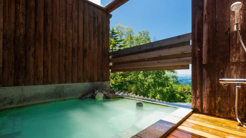 een zwembad met water in een houten gebouw met een raam bij Mogamitakayu Zenshichinoyu Ohira in Zao Onsen