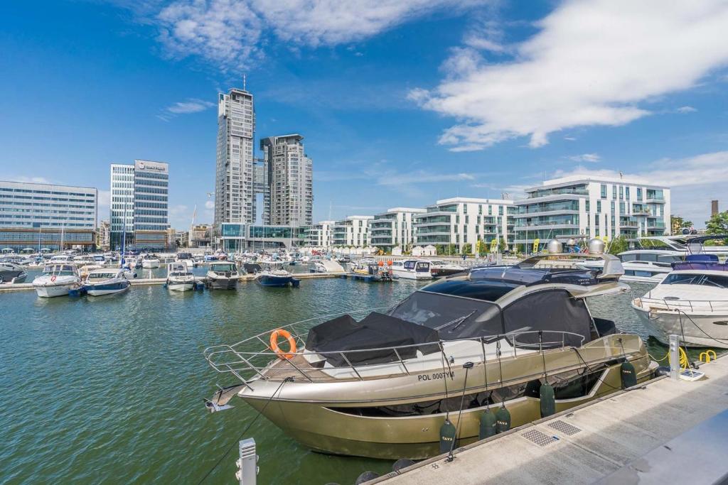 una barca è ormeggiata in un porto turistico con altre imbarcazioni di Apartament Faltom 20 Yacht Park Premium a Gdynia