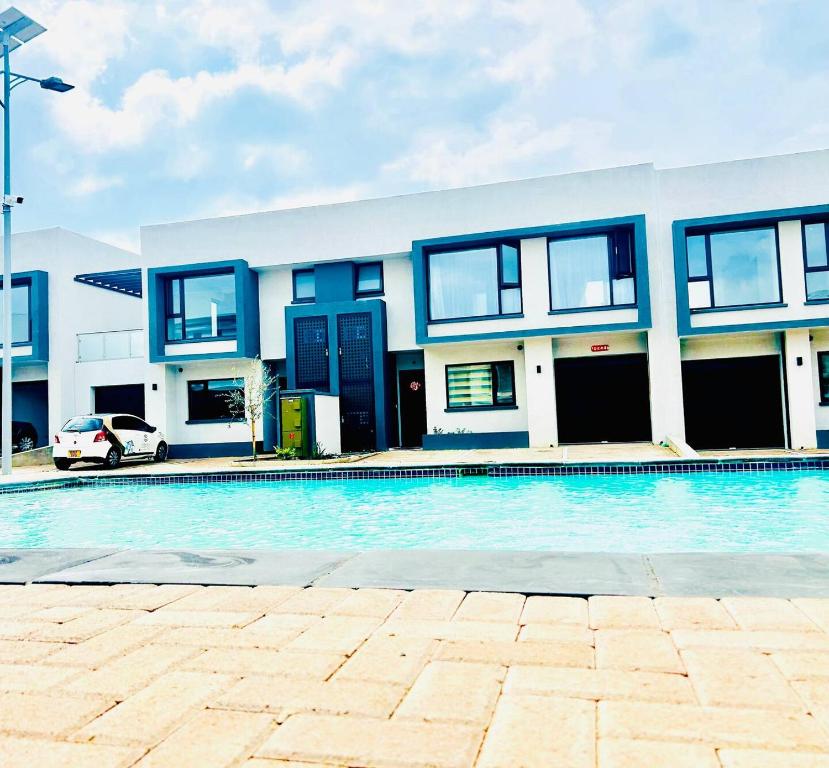 uma casa com piscina em frente a um edifício em Studio 19 apartments em Gaborone