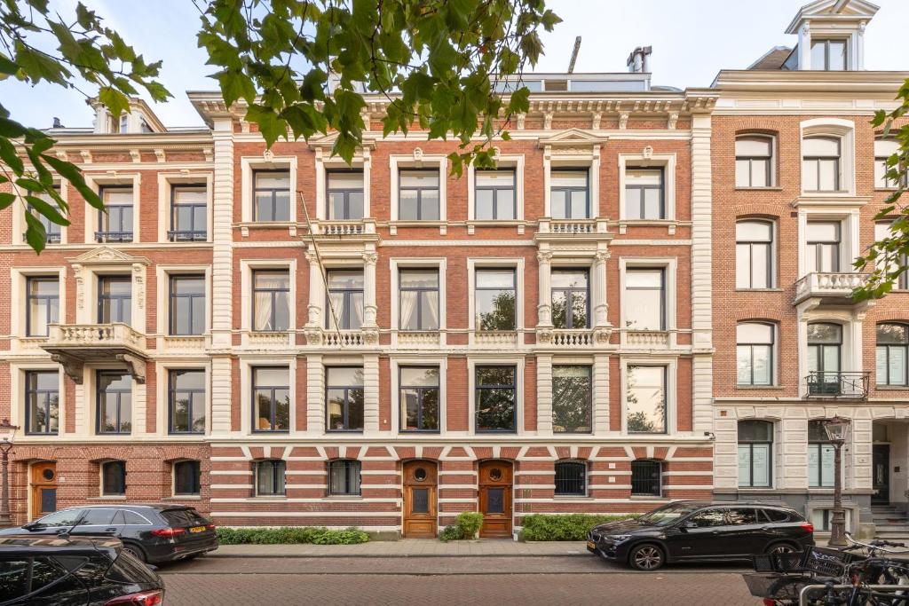 een groot bakstenen gebouw met auto's geparkeerd voor het bij Park Mansion Hotel in Amsterdam