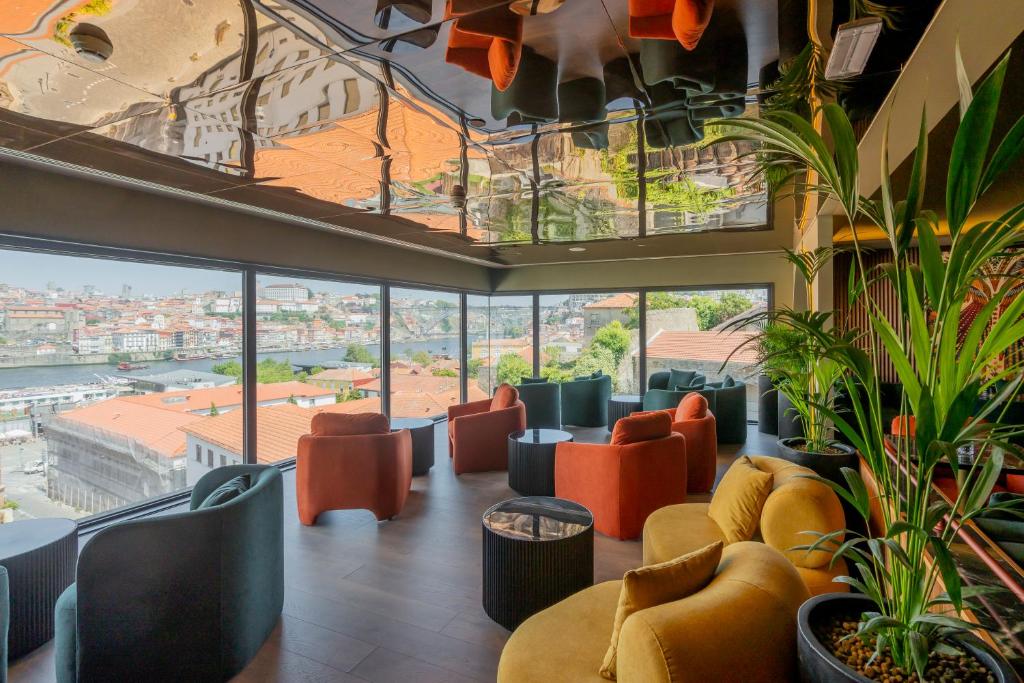 una sala d'attesa con sedie arancioni e ampie finestre di Hilton Porto Gaia a Vila Nova de Gaia