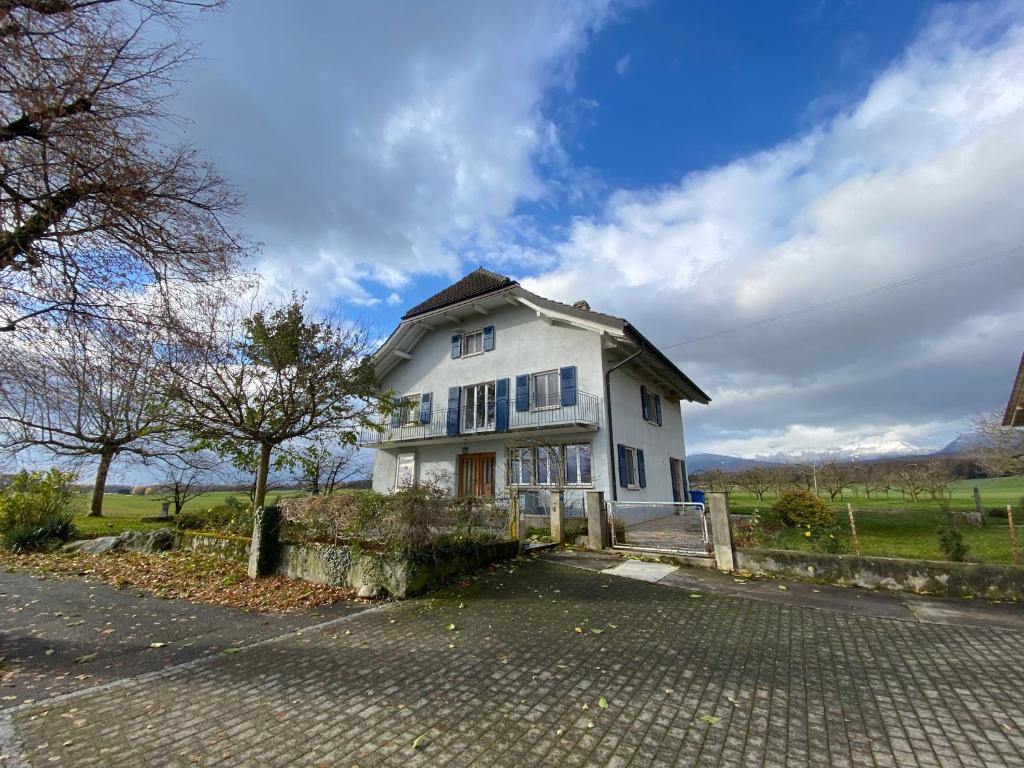 ein weißes Haus am Straßenrand in der Unterkunft B&B Domaine En Trembley in Commugny