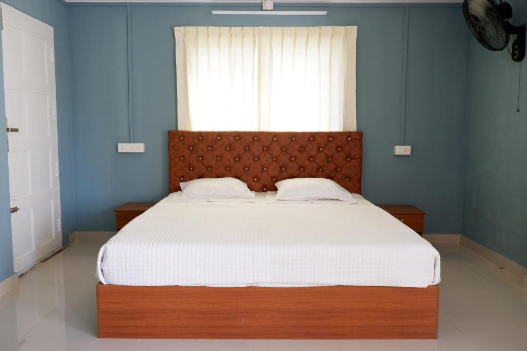 um quarto com uma cama grande e um cobertor branco em Haya Residency em Alappuzha