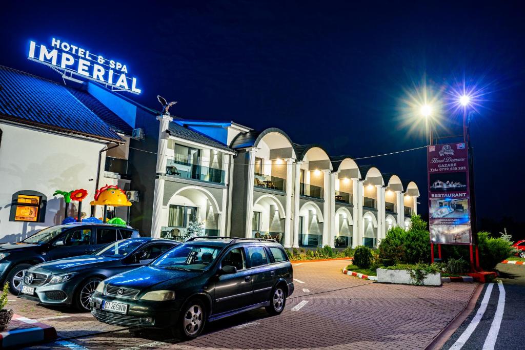 un'auto parcheggiata in un parcheggio di fronte a un edificio di Hanul Domnesc Imperial Hotel & SPA a Călan