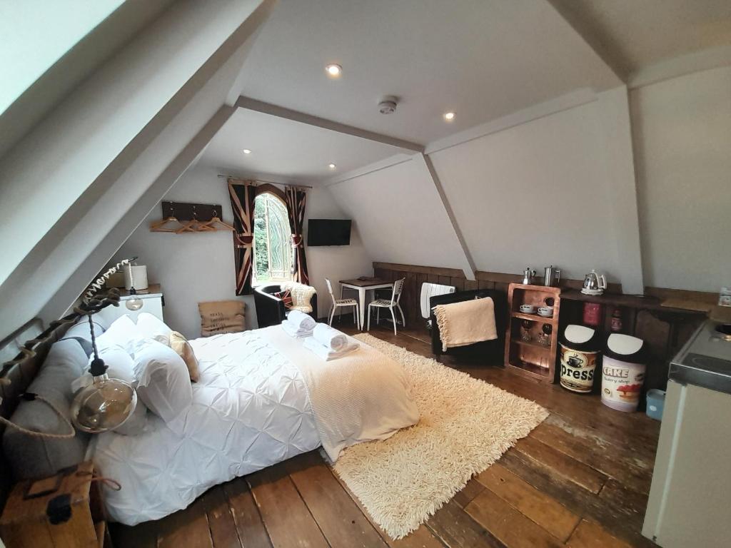 - une chambre mansardée avec un grand lit dans l'établissement Quaint Studio Loft Room nr Hampton Court, à Thames Ditton