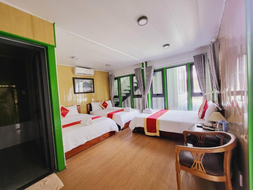 una habitación de hotel con 3 camas y una silla en Phúc Đạt Container, en Vung Tau