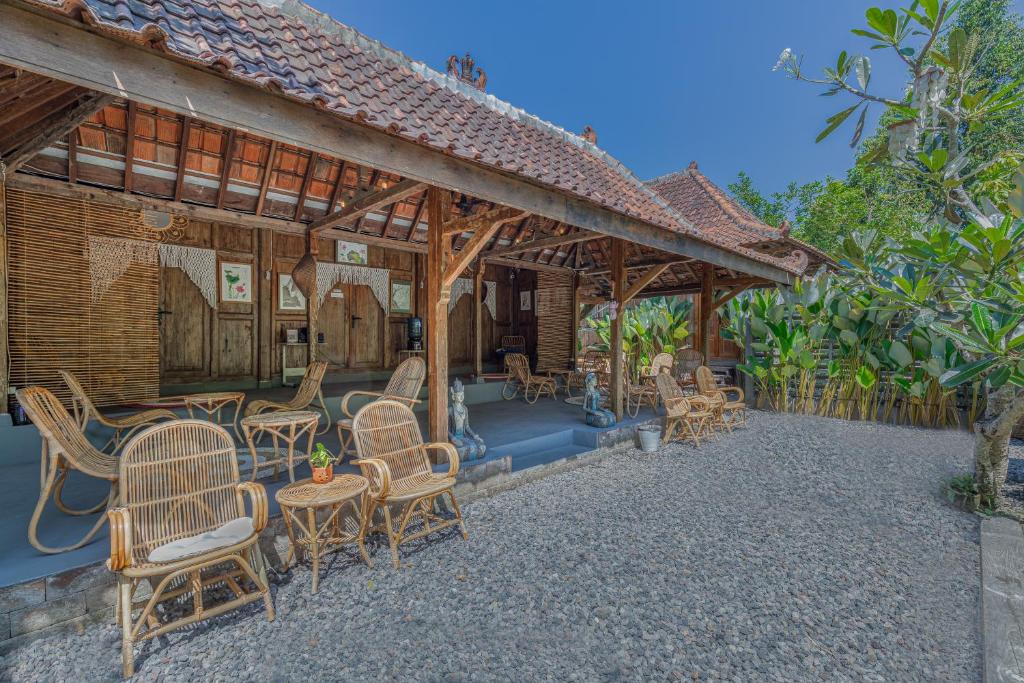 een patio van een huis met stoelen en tafels bij Yukke Tembi Homestay in Yogyakarta