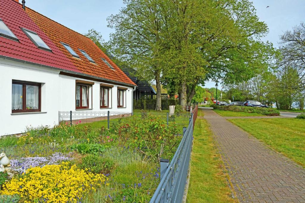 een tuin naast een huis met een hek bij schoene Ferienwohnung mit Terrasse in Ralswiek