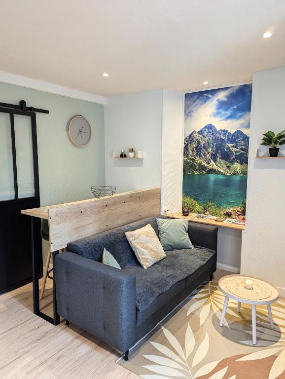 sala de estar con sofá y ventana grande en Appartement au cœur des alpes, en Albertville