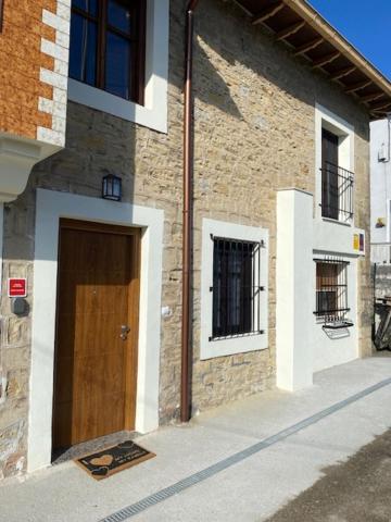 サンティリャーナ・デル・マルにあるCasa los Patos en Santillana Del Marの通り側の木製の扉のあるレンガ造りの建物