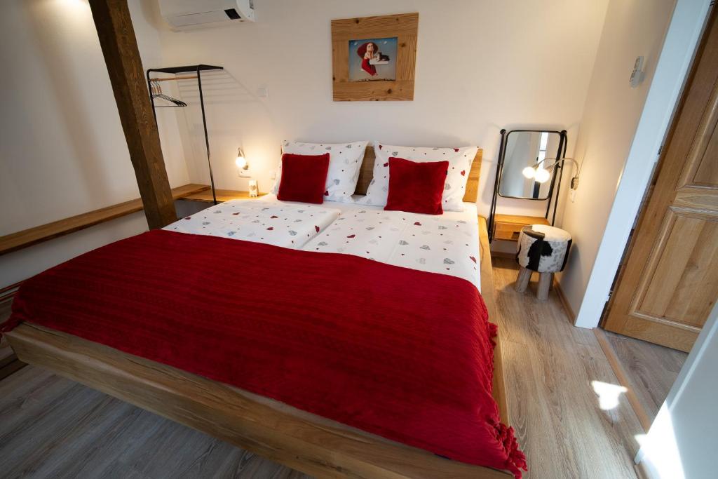 ein Schlafzimmer mit einem großen Bett mit roten Kissen in der Unterkunft Apartmány & Wellness Revenite in Jeseník