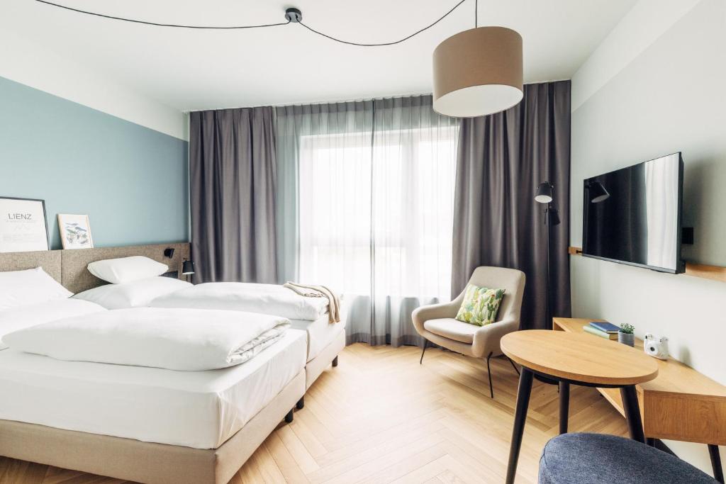 a hotel room with two beds and a table at harry's home Graz-Smart City hotel & apartments in Graz