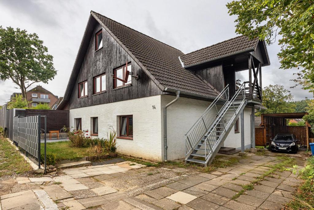 een huis met een zwart-wit dak bij Gemütliche Wohnung Buchholz i d N in Buchholz in der Nordheide