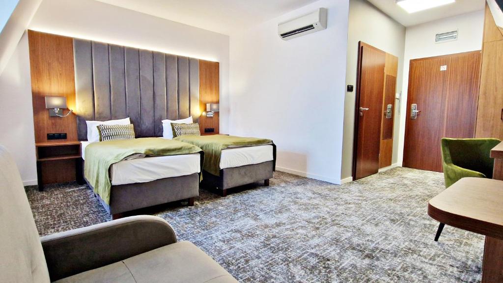 a hotel room with two beds and a couch at Hotel Korona Spa & Wellness in Lublin