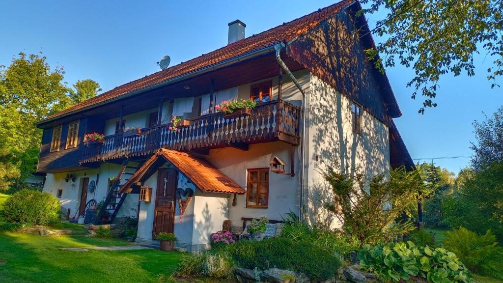 een wit huis met een veranda en een balkon bij Chaloupka u Jiřího in Nová Pec