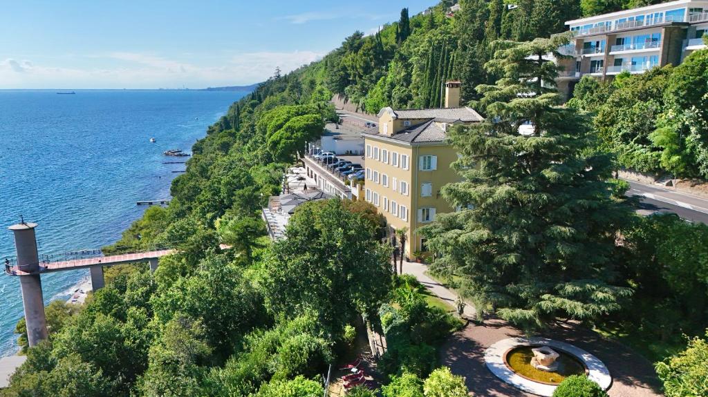 un edificio en una colina junto al océano en Hotel Riviera & Maximilian's, en Trieste