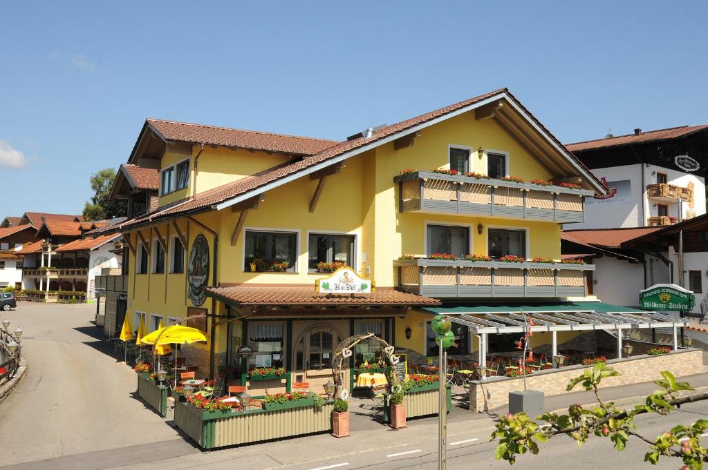 un bâtiment jaune dans une rue d'une ville dans l'établissement Appart-Hotel Wildererstuben, à Bodenmais