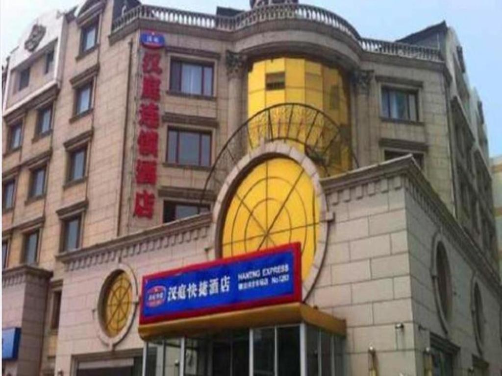 un edificio con un reloj al costado. en Hanting Hotel Tianjin Tanggu Foreign Commodities Market, en Binhai